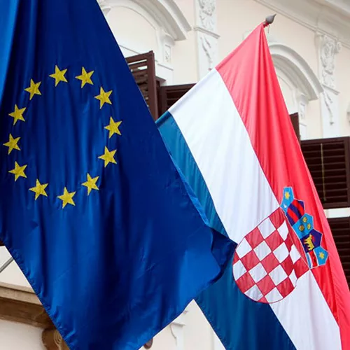 Banderas de Croacia (dcha) y la Unión Europea (izda) ondean en un edificio gubernamental en Zagreb, ©EFE